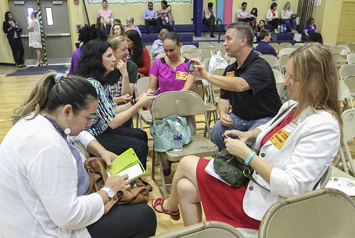 While the students were away for some 90 minutes competing in the Battle of the Books semifinals, St. John Neumann Regional School parents (counterclockwise, from middle left) Meg Rubin, Urcina Soto, Aneta Mazurkiewicz, Tres Scott, Nicole Smith and Amy Lampert found ways to keep themselves busy in the school gymnasium. Lampert had a daughter competing on the sixth-grade team, but she is also a fifth-grade teacher at the school. Photo By Michael Alexander