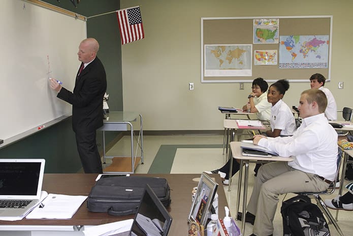 Human Geography instructor John Henry Spann, left, draws an illustration on the board as he poses a question to his class with moral and social implications. Photo By Michael Alexander