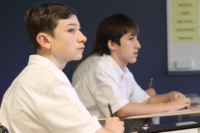 The eyes of Sebastian Kidder, foreground, and Andrew McElroy, background, follow their teacher, Lynne Bombard, as she talks and moves across the room at the same time in the morning Design class. Photo By Michael Alexander