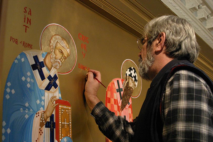 Father Dimitri Leussis writes the name of St. Gregory Dialogos, Pope of Rome, on the wall. Next to St. Gregory appear (l-r) St. Cyril of Alexandria, St. Gregory the Theologian and St. John Chrysostom. Photo By Michael Alexander