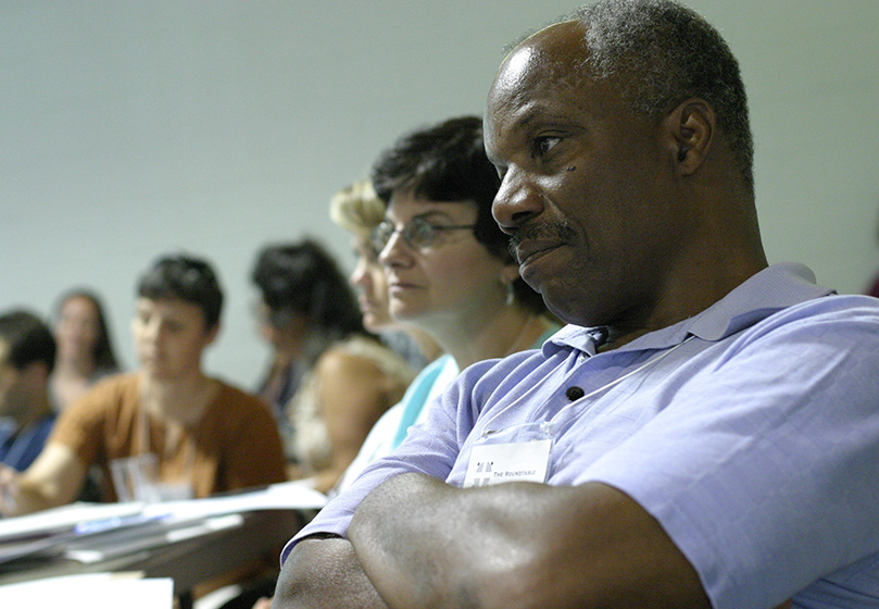 Foreground to background) Frank McKinney III, a member of the Diocese of Richmond's Black Catholic Commission, and Dorothy Grillo, Catholic Relief Services southeast regional director, listen to Father Bryan Massingale's presentation as they join 96 others for the Advanced Symposium on Racism. Photo By Michael Alexander