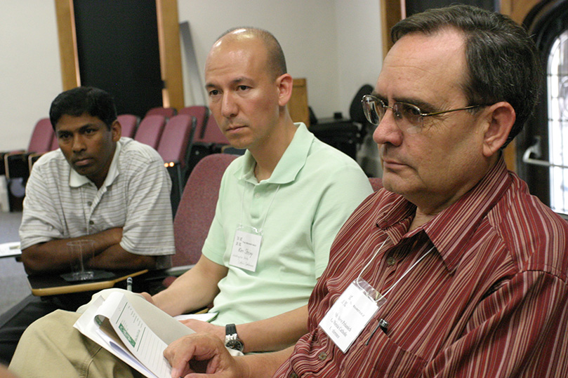 (Foreground to background) Steve Pehanich, senior director of advocacy and education for the California Catholic Conference, Sacramento, Kim Sheley, legislative director for the Washington State Catholic Conference, Seattle, and LaSalette priest Father Johny Vadakkan, parochial vicar at St. Ann Church, Marietta, listen as one of their discussion partners shares his experiences in the arena of social justice. Photo By Michael Alexander