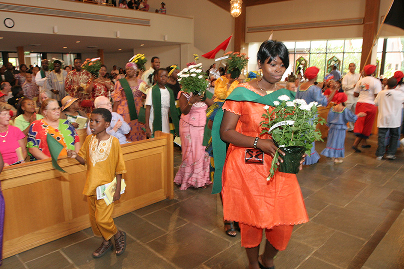 Parishioners participate in the opening procession of the 10th annual multicultural Mass and festival at St. Philip Benizi Church, Jonesboro. Some 40 different countries were represented at the Sept. 27 celebration. Photo By Michael Alexander