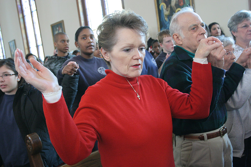 Lorraine Brunelle and her husband Richard join hands as they pray the Our Father during the Mass for the Unborn. The Brunelles attend Saint Mary Magdalene Catholic Church, Newnan. Photo By Michael Alexander