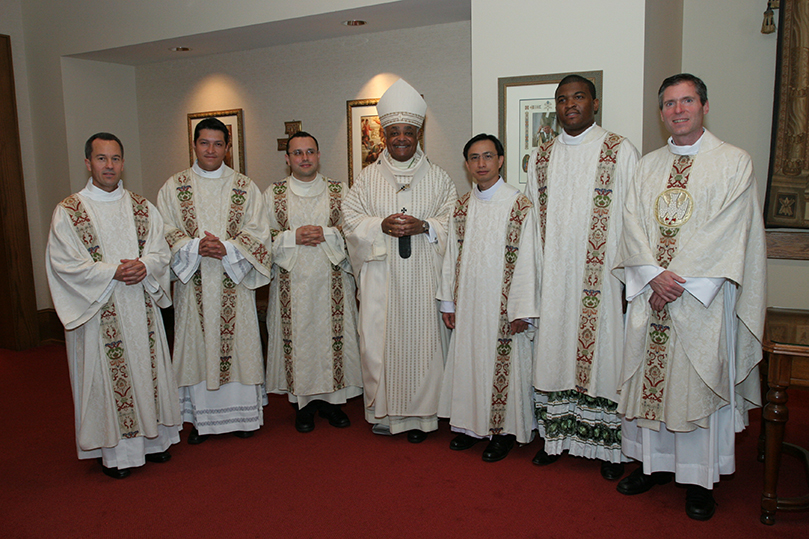 Archbishop Wilton D. Gregory, center, and Father Luke Ballman, director of vocations, far right, join the newly ordained transitional deacons (l-r) Thomas Zahuta, Mario Lopez-Castro, Carlos Vargas Silva, Thang Minh Pham and Chijioke Ogbuka for a group photo following the rite of ordination. Photo By Michael Alexander