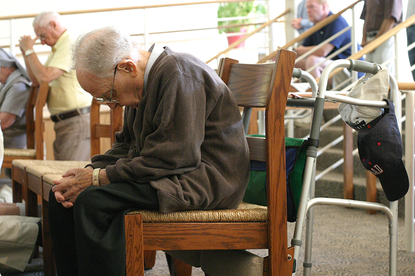 Jim Kelly bows his head in prayer during the 9:15 a.m. Mass at Holy Cross Church, Atlanta. Although Kelly is unable to attend daily Mass as often as he once did, for many years he served as the parish sacristan. Photo By Michael Alexander