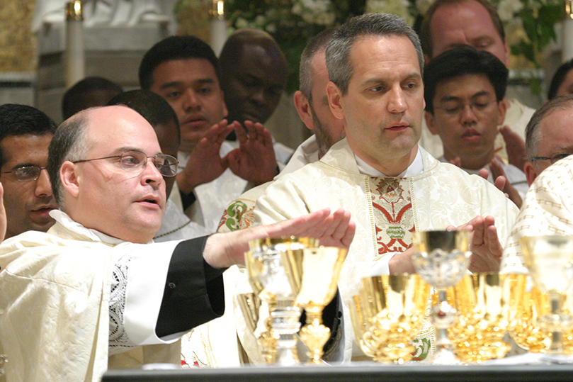 New priests Father Omar Loggiodice, left, and Father Brian Lorei join their brother priests before the altar during the Liturgy of the Eucharist. Photo By Michael Alexander