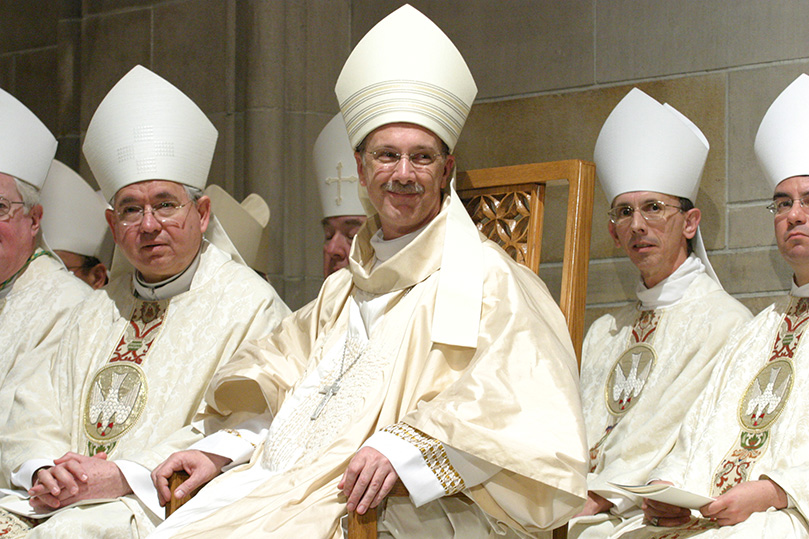 Bishop Luis Zarama displays a smile toward the congregation as he sits among his brother bishops.