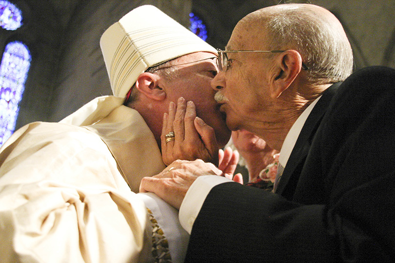 As he walks out among the congregation to give them a blessing, Bishop Luis Zarama first stops by the pew of his parents, where they both give him a supportive hug and kiss.