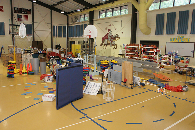 A foot and a half of water filled the St. John Nuemann gymnasium on the day of the flash flood. On the gymnasium floor sit the items they were able to salvage.