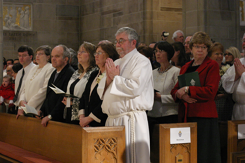 Ordination candidate Francis Devereux, center, of St. Joseph Church, Marietta, stands with his family in the pew during the opening procession. Devereux had relatives in attendance from California, New Jersey and Ireland. Photo By Michael Alexander