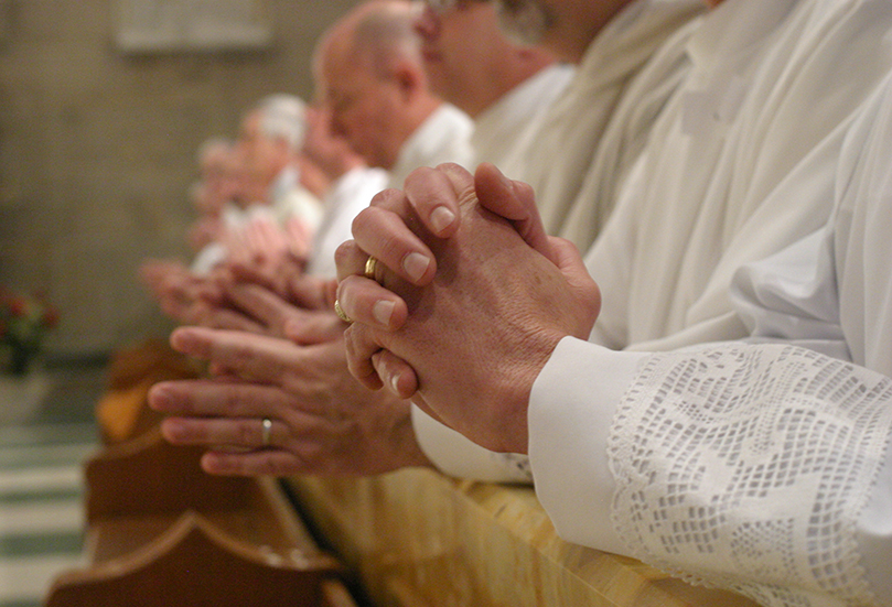 All 15 permanent deacon candidates kneel at the Communion rail as Archbishop Gregory conducts the prayer of consecration during their Feb. 4 rite of ordination at the Cathedral of Christ the King, Atlanta. Photo By Michael Alexander