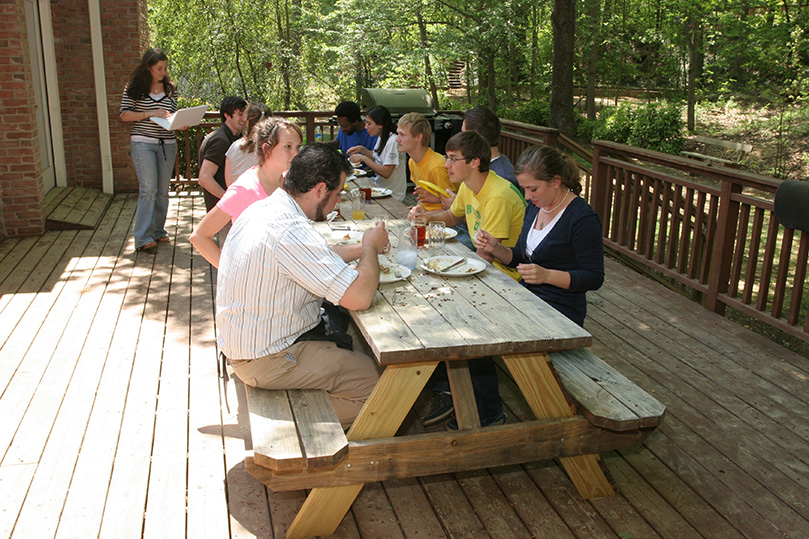 Following Mass students and campus ministry staff partake in a family style meal prepared by campus minister Christopher Dehner, foreground left. The menu included rice with chicken, beans, bread, flan and salad. A congregation of nearly 25 people attends Mass at the Kennesaw State University Catholic Center, April 15. Photo By Michael Alexander