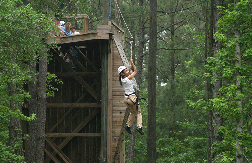 Tiffney Minor, 23, of Suwanee takes a ride on the zip line during Toni's Camp, May 1. The weekend camp allows individuals with physical or mental disabilities to engage in spiritual, social and recreational activities on the grounds of Camp Twin Lakes, Rutledge. Photo By Michael Alexander