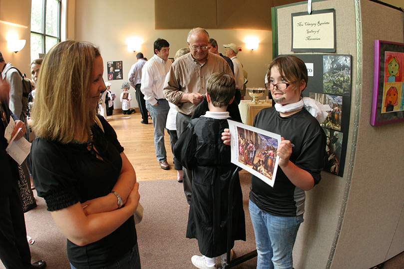 Emily Rezac, right, portrays Spanish Renaissance artist El Greco, as she provides a brief presentation to St. Jude School parent Amy Williamson. Photo By Michael Alexander