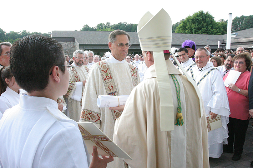 Deacon Terry Bigelow, facing camera center, presents the church plans to Bishop Luis Zarama at the entrance to the new St. John Neumann Church. Bigelow, a deacon at Our Lady of the Assumption Church, Atlanta, was the architect for the project. Photo By Michael Alexander