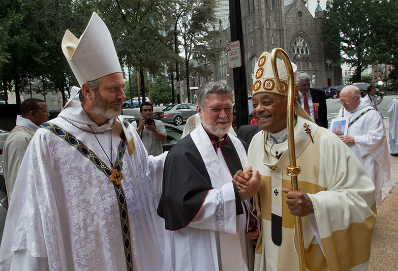 Monastery of the Holy Spirit Abbot, Francis Michael Stiteler, left, and Archbishop Wilton D. Gregory, right, offer words of congratulation to basilica rector Father T. J. Meehan following the Mass of Elevation. Photo by Thomas Spink