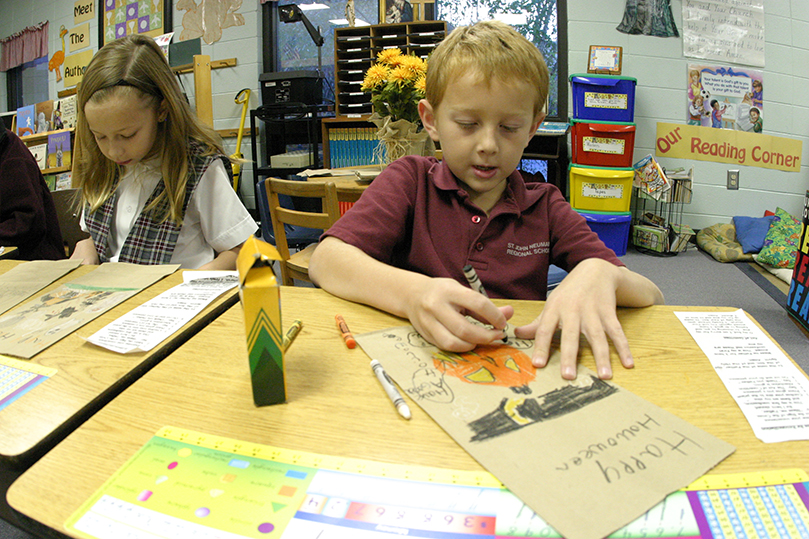 St. John Neumann School second-grader James Frias decorates a bag during a service undertaking for Atlanta's Project Open Hand. The nonprofit was founded in 1988 