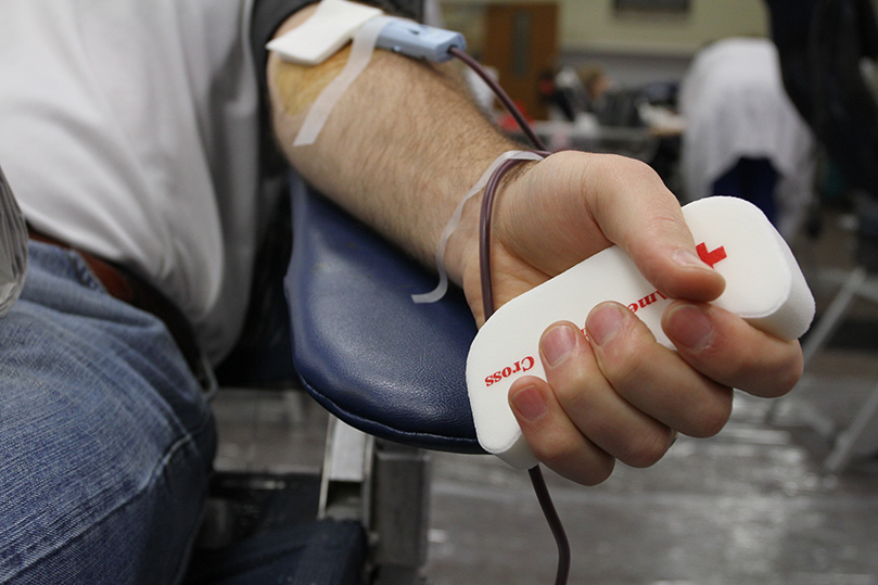 Holy Cross Church parishioner Brian Arnberger squeezes out a unit of blood during the Dec. 11 Bob Buechner Blood Drive. Photo By Michael Alexander