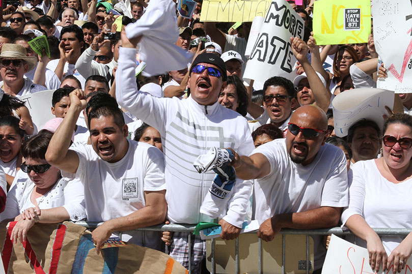 (Front row, starting third from the left) Mario Martinez and Saul Hernandez of Atlanta, Saul Miranda of Forest Park and Vanessa Kosky of Atlanta respond to the positive encouragement from one of the rally speakers. Photo By Michael Alexander