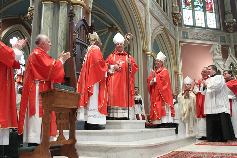 Amid smiles and rousing applause, Bishop Gregory John Hartmayer takes his place at the cathedra, the bishop’s official chair, as the new bishop of Savannah. Photo By Michael Alexander