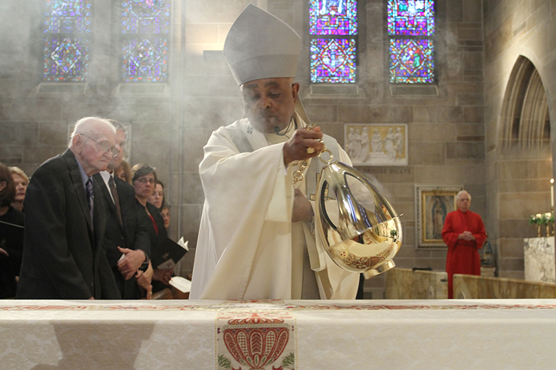 Archbishop Wilton D. Gregory, right, censes the body of Archbishop John F. Donoghue during the final commendation at the funeral Mass. Photo By Michael Alexander