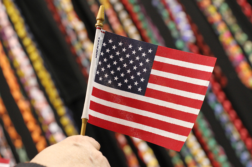 A handheld flag is displayed against a backdrop of paper chains during the celebration of kindness and service on Veterans Day. The event was sponsored by 11Alive, Georgia Natural Gas and the Home Depot Foundation. Photo By Michael Alexander