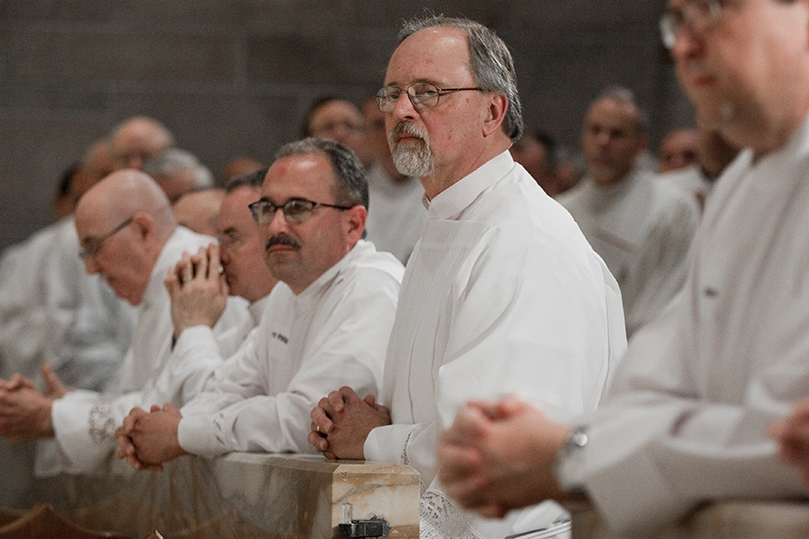 Tom Walter, right center, of Prince of Peace Church, Flowery Branch, and Barry Phillips, left center, of Sacred Heart of Jesus Church, Hartwell, kneel at the Communion rail during the prayer of consecration. Photo By Thomas Spink/Archdiocese of Atlanta