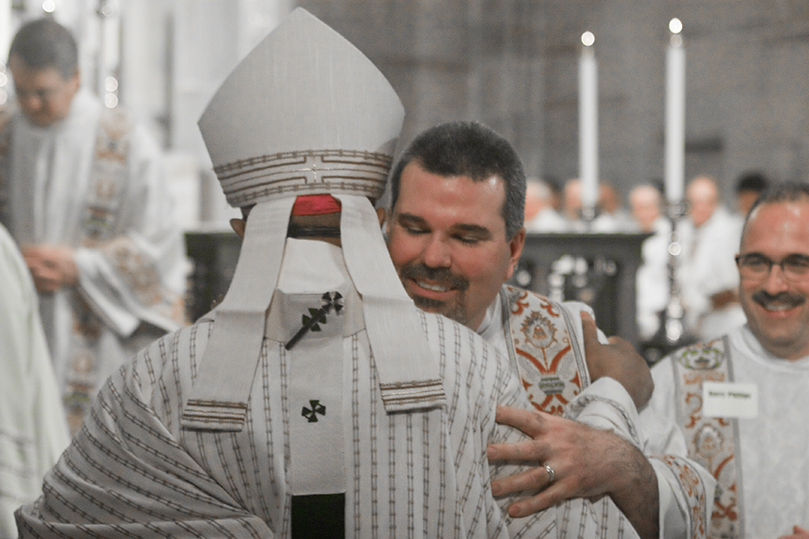 Deacon Thomas McGivney of St. Thomas Aquinas Church, Alpharetta, shares the kiss of peace with Archbishop Wilton D. Gregory. Photo By Thomas Spink/Archdiocese of Atlanta