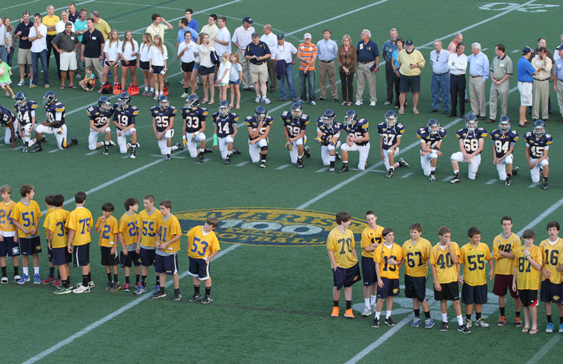 (Foreground to background) Seventh, eighth, and ninth grade football players, current players and football alum (cheerleaders, managers, players and their families) join each other on the field of Hughes Spalding Stadium for a pre-game celebration marking 100 years of Marist football. Photo By Michael Alexander