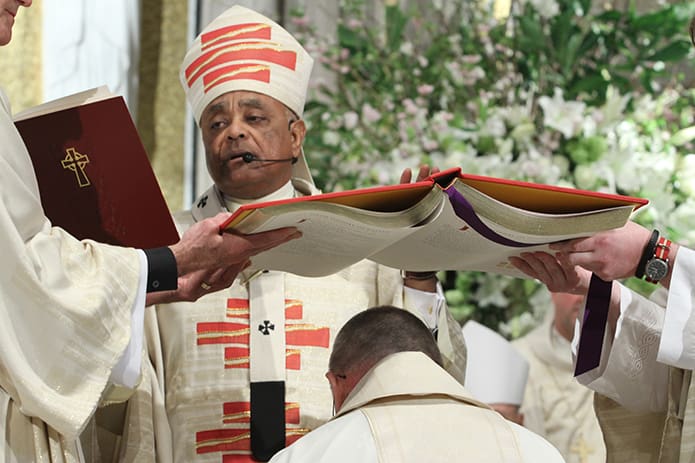 The Book of the Gospels is held over Bishop-designate David Talley as Archbishop Gregory conducts the Prayer of Ordination, the final step in conferral to the Office of the Episcopacy. Photo By Michael Alexander