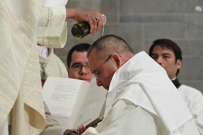 Archbishop Wilton D. Gregory pours the Sacred Chrism over the head of Bishop David Talley. Photo By Michael Alexander