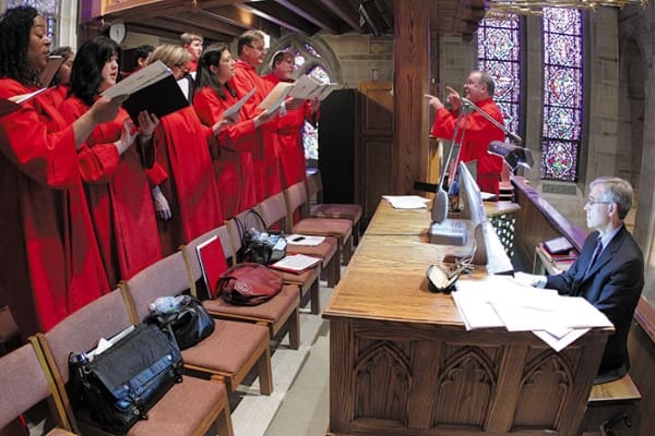 Cathedral of Christ the King choirmaster Kevin Culver directs the choir as Tim Wissler accompanies them on organ. In April Archbishop Gregory provided Culver with a copy of the original 1973 ordination program so they could replicate the music for the May 9 Mass. Photo by Michael Alexander