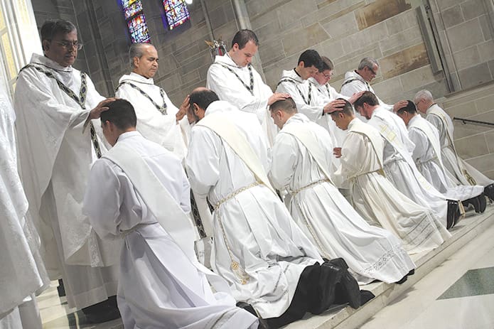 Archdiocesan and visiting priests lay hands upon the seven ordination candidates during their June 8 ordination to the priesthood at the Cathedral of Christ the King, Atlanta. Archdiocesan and visiting priests lay hands upon the seven ordination candidates during their June 8 ordination to the priesthood at the Cathedral of Christ the King, Atlanta. Photo By Michael Alexander