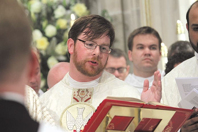 Father Dennis Dorner Jr. takes his turn reading from the eucharistic prayer. Dorner is the only priest in the class of 2013 who is a native of Atlanta. His first assignment will be at St. Thomas More Church, Decatur. Photo By Michael Alexander