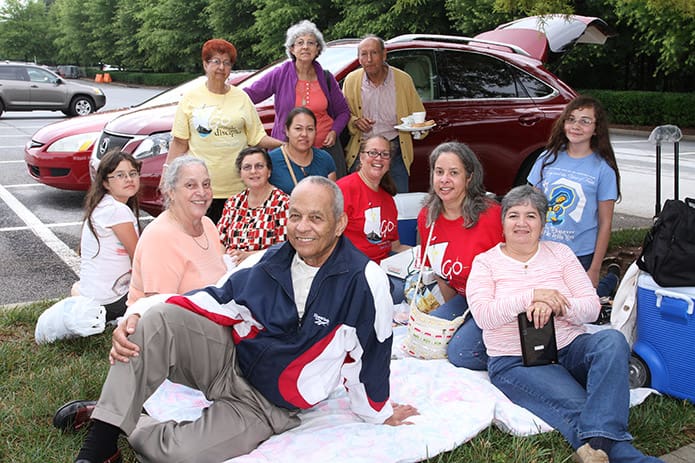 The Diaz, Moncada, Onofre, Piedrahita, Serrano and Vasquez family share a meal outdoors while the traffic leaving the Georgia International Convention Center dies down. All six families attend Immaculate Heart of Mary Church in Atlanta. Photo By Michael Alexander