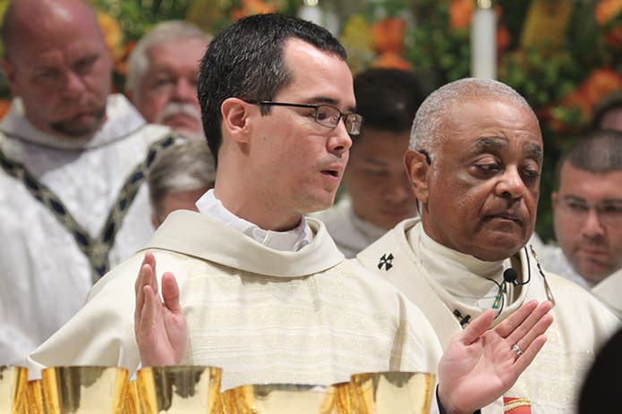 Father Brian Baker reads from the Eucharistic prayer for the first time as a new priest. Baker has been assigned to St. Brigid Church, Johns Creek, until he returns to Rome, Italy for further study. Photo By Michael Alexander