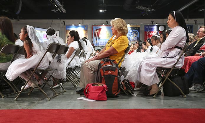 The congregation, a combination of youth and adults, listen to Bishop Robert Lynchâs homily. Photo By Michael Alexander