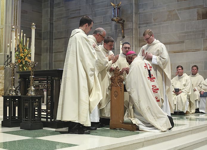 Just before the concluding rites, all five of the new priests (l-r) Father Brian Bufford, Father Mark Thomas, Father Branson Hipp, Father Jorge Carranza and Father Timothy E. Nadolski bestow a joint blessing upon Archbishop Wilton D. Gregory. Photo By Michael Alexander