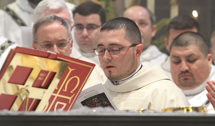 Father Jorge Carranza, center, takes his turn reading from the eucharistic prayer. Father Carranzaâs first priestly assignment will be at Church of the Good Shepherd in Cumming. Photo By Michael Alexander