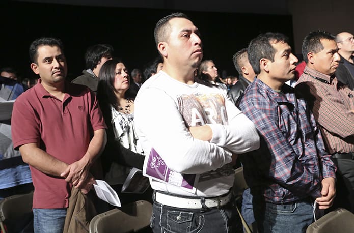 (L-r) Juan Gomez and Juan Loredo of St. John Neumann Church, Lilburn, stand up as sponsors for candidates like Bonifacio Vicente during the call to continuing conversion. Photo By Michael Alexander