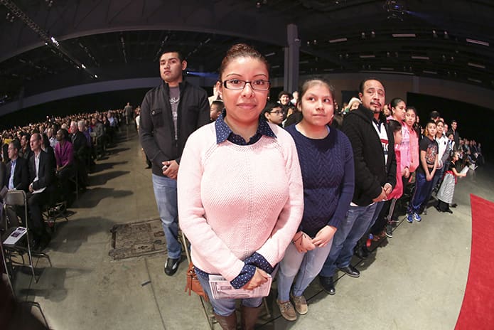 Yolanda Toxtle of Immaculate Heart of Mary Church, Atlanta, center, stands with her 12-year-old daughter Nicole, a catechumen, and her husband Felix Varela. In the background, standing left, is Luis Sanchez, who was serving as a godparent for a catechumen. Photo By Michael Alexander