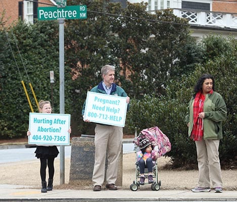 L-r) Nine-year-old Kathleen McGarry of St. Michael the Archangel Church, Woodstock, stands with David Johnson, his 3-year-old daughter Sofia and his wife Priya of St. Catherine of Siena Church, Kennesaw, during Stand for Life. Photo By Michael Alexander