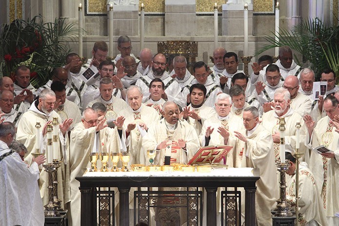 Archbishop Wilton D. Gregory, center, is joined at the altar by his brother clergy during the Liturgy of the Eucharist at the 2016 Chrism Mass. Photo By Michael Alexander