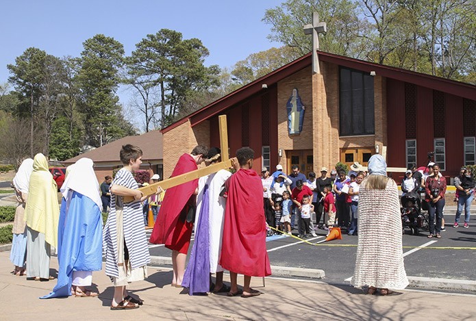 Simon of Cyrene (played by Samuel Peterson), rear of cross, helps Jesus (played by Darryl Cooper) carry his cross during this depiction of the fifth Station of the Cross. Photo By Michael Alexander