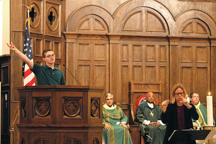 D. J. Peyroux proclaims the first reading and responsorial psalm, as Brenda French signs, at the Faith and Sharing Mass. He is a high functioning person with autism, and his parents were told that he would never speak when he was born. PHOTO BY LAURA MOON