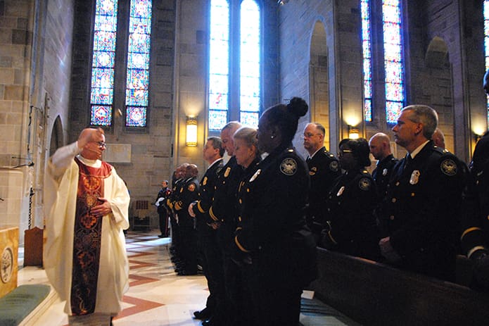 Msgr. Francis G. McNamee, rector of the cathedral, blesses the public safety officials and first responders present at the Blue Mass. In his homily, Msgr. McNamee emphasized the importance of remembering the events of 9/11, when “ordinary” people came together to aid others. PHOTO BY LAURA MOON.