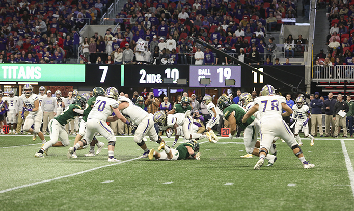 Blessed Trinity High School outside linebacker Alex Poma, on the ground, upends Cartersville High School running back Marcus Gary. The Blessed Trinity defensive unit held Carterville to three field goals in the team's 23-9 victory. Photo By Michael Alexander