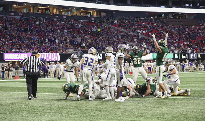 Blessed Trinity High School sought to seal the victory with its final touchdown of game, a one-yard quarterback sneak by Jake Smith. Running back Steele Chambers (#22) and tight end James Bryant (#81) provide a signal for clarification. Five minutes later the team would repeat as state champions with a 23-9 win over Cartersville High School. Photo By Michael Alexander