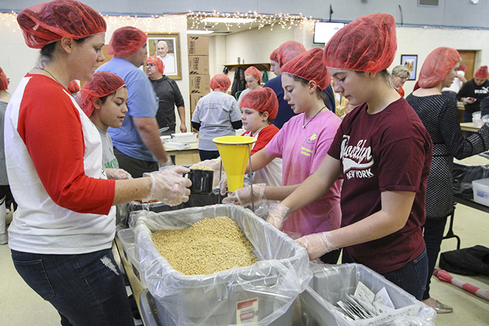 This is the fifth year in a row Shannon Gaines, foreground left, and her family have participated in the Catholic Relief Servicesâ Helping Hands event at Holy Trinity Church, Peachtree City. Gaines was joined by (counterclockwise, from foreground right) her daughters Ashlyn, 15, Addison, 12, and Eliana, 8, and her niece Dalayla Giles, 16. Photo By Michael Alexander